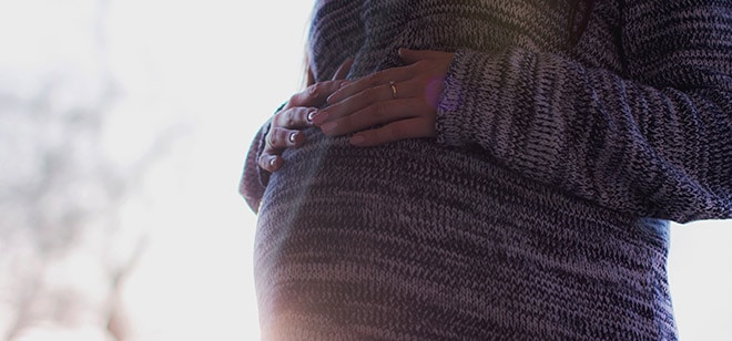 Vrouw zwanger in dikke trui